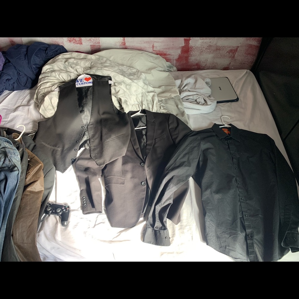 Suite jacket, black collared shirt, vest